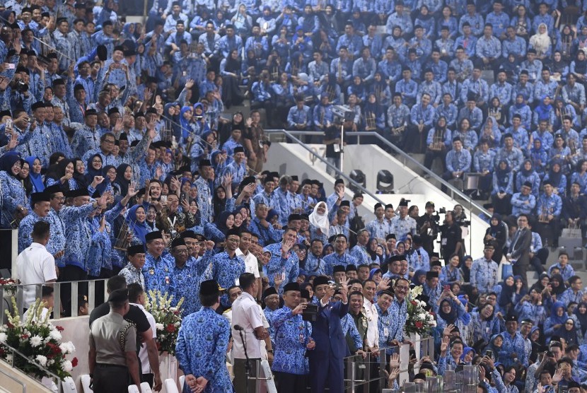 Presiden Joko Widodo (tengah) berswafoto dengan Aparatur Sipil Negara (ASN) saat peringatan Hari Ulang Tahun Korps Pegawai Republik Indonesia (KORPRI) ke-47 di Istora Senayan, Jakarta, Kamis (29/11/2018).