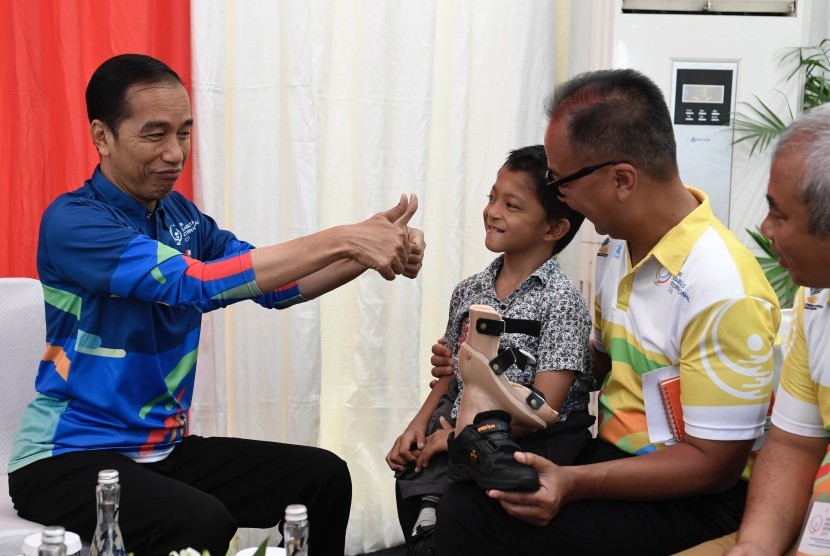 Presiden Joko Widodo (kiri) bersama Menteri Sosial Agus Gumiwang K berbincang dengan siswa penyandang disabilitas asal Sukabumi Mukhlis Abdul Holik (kedua kanan) disela Peringatan Hari Disabilitas Internasional Tahun 2018 di Bekasi, Jawa Barat, Senin (3/12/2018). 