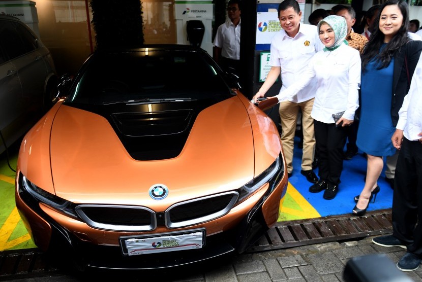 Menteri ESDM Ignasius Jonan (kiri) didampingi Dirut Pertamina Nicke Widyawati (tengah) dan VP of Corporate Communication BMW Group Indonesia Jodie O'tania (kanan) melakukan pengisian mobil listrik BMW i8 Roadster saat peluncuran Green Energy Station (GES) Pertamina di Jakarta, Senin (10/12/2018).