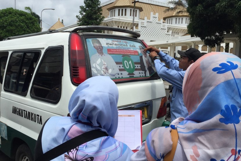  Bawaslu Kota Tasik melakukan penindakan berupa pencopotan stiker  kampanye yang terpasang pada angkutan kota (Angkot) pada Selasa (11/10).