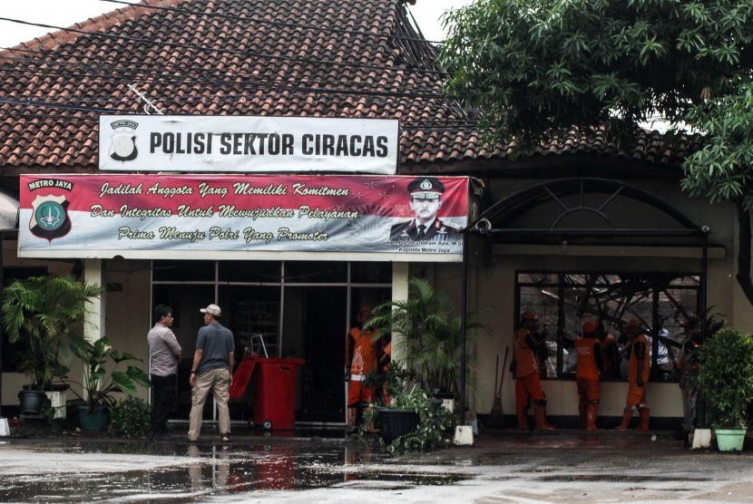 Petugas kepolisian beraktivitas usai perusakan dan pembakaran Polsek Ciracas, di Jakarta, Rabu (12/12/2018).