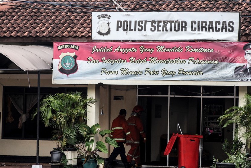 Petugas pemadam kebakaran bergegas seusai memadamkan api yang melanda Polsek Ciracas, Jakarta, Rabu (12/12/2018).