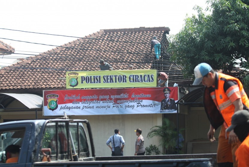 Petugas kepolisian memperbaiki kantor Polsek bekas perusakan dan pembakaran di Polsek Ciracas, di Jakarta, Kamis (13/12/2018). 