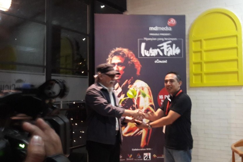 Iwan Fals secara simbolis memberikan bibit pohon kepada perwakilan MD Media sebelum konser Nyanyian yang Tersimpan di Live Space, SCBD, Jakarta, Ahad (16/12).