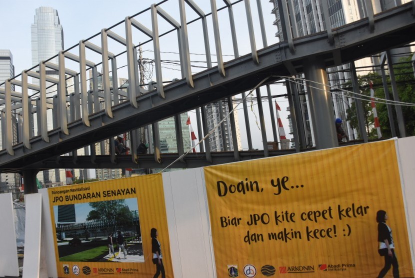 Pekerja melakukan pengerjaan proyek revitalisasi Jembatan Penyeberangan Orang (JPO) Bundaran Senayan di Jakarta, Senin (17/12/2018). 