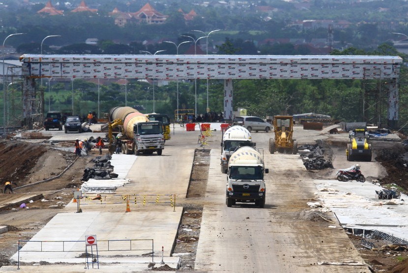 Pekerja menyelesaikan pembangunan jalan tol Pandaan-Malang di pintu keluar Karanglo, Malang, Jawa Timur, Rabu (19/12/2018).
