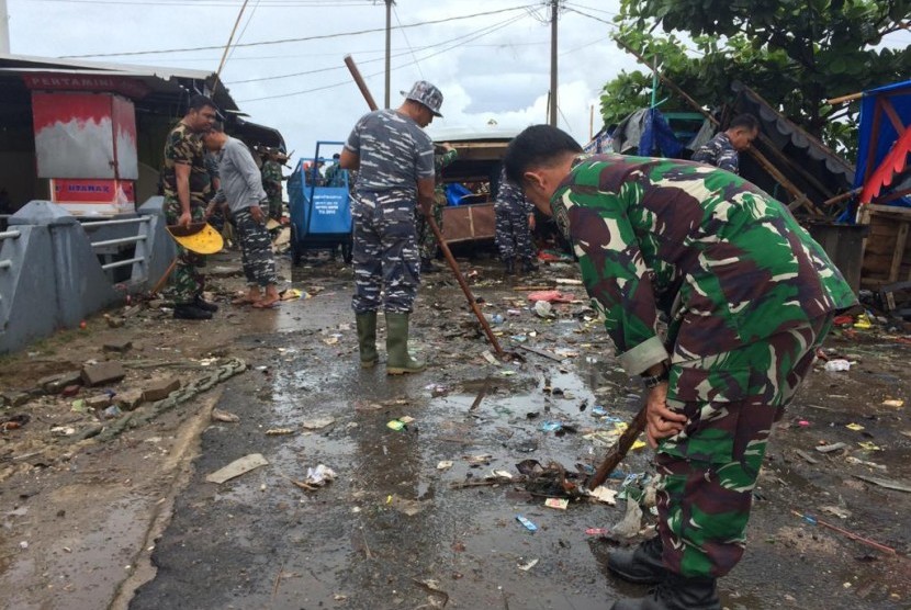 Prajurit TNI AL membersihkan puing-puing di sekitar Pos Pengamatan TNI AL Labuan, Kampung Nelayan I, Desa Teluk, Kecamatan Labuan, Kabupaten Pandeglang, Banten, Senin (24/12). 