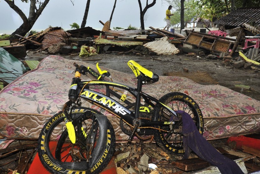 Warga menyelamatkan barang-barang miliknya dari reruntuhan rumah yang roboh dihantam tsunami di Kampung Pasawahan, Carita, Pandeglang, Banten, Senin (24/12/2018). 