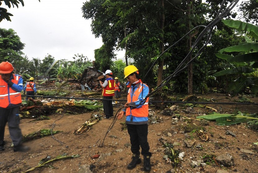 Sejumlah pekerja PT PLN membetulkan kabel jaringan listrik yang terputus akibat dihantam gelombang tsunami di Kawasan Wisata Carita, Pandeglang, Banten, Senin (24/12/2018). 