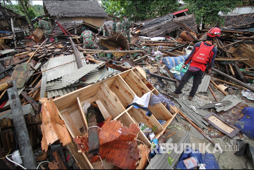 Personel TNI bersama relawan mencari korban tsunami dari balik reruntuhan rumah di Sumur Pesisir, Pandeglang, Banten, Senin (24/12/2018). 