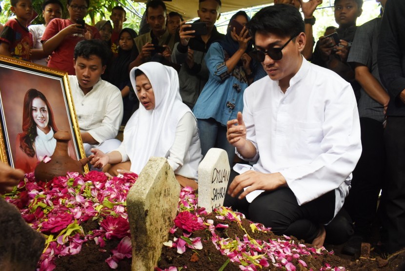 Vokalis band Seventeen, Riefian Fajarsyah alias Ifan (kanan) berdoa di makam istrinya Dylan Sahara seusai pemakaman di Tempat Pemakaman Umum Tamanarum, Kabupaten Ponorogo, Jawa Timur, Selasa (25/12/2018).