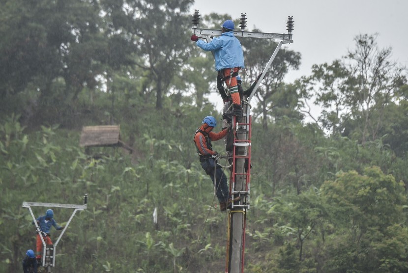 Petugas PLN melakukan perbaikan jaringan listrik pasca tsunami Selat Sunda di jalan raya Tanjung Lesung, Pandeglang, Banten, Selasa (25/12/2018). 