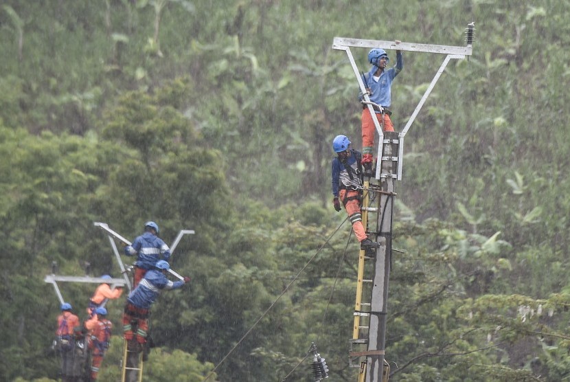 Petugas PLN melakukan perbaikan jaringan listrik pasca tsunami Selat Sunda di jalan raya Tanjung Lesung, Pandeglang, Banten, Selasa (25/12/2018). 