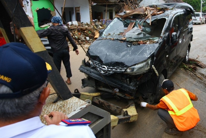 Petugas Dinas Perhubungan Provinsi Banten dan Polda Banten melakukan evakuasi bangkai kendaraan yang berserakan di sejumlah penginapan yang terhempas gelombang tsunami di Carita, Pandeglang, Banten, Selasa (25/12/2018).