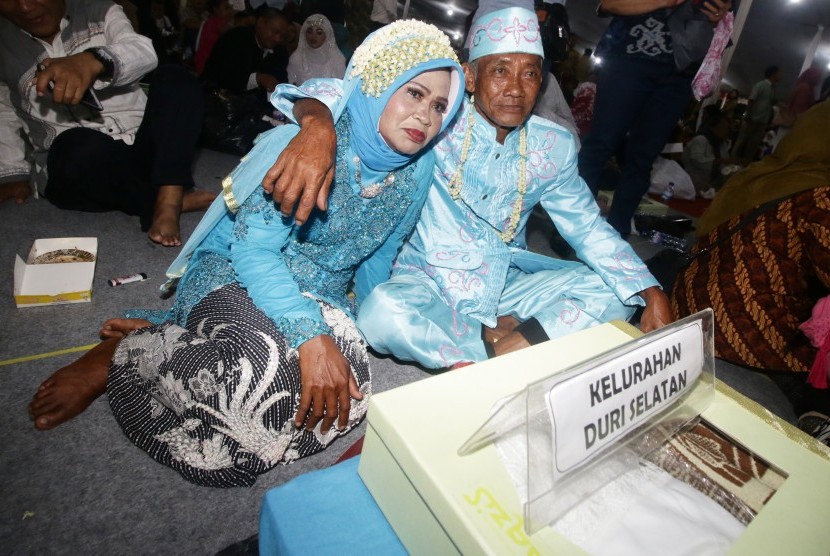 Pasangan pengantin bersiap mengikuti nikah massal di Thamrin Park Ride, Jakarta, Senin (31/12/2018).