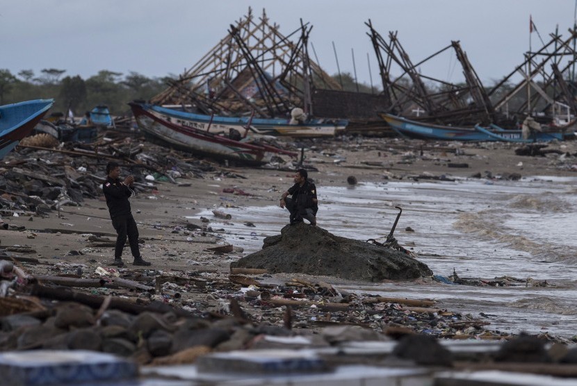 Warga memotret rekannya di antara puing-puing yang rusak karena tsunami Selat Sunda di Sumur, Pandeglang, Banten, Kamis (3/1/2019). 