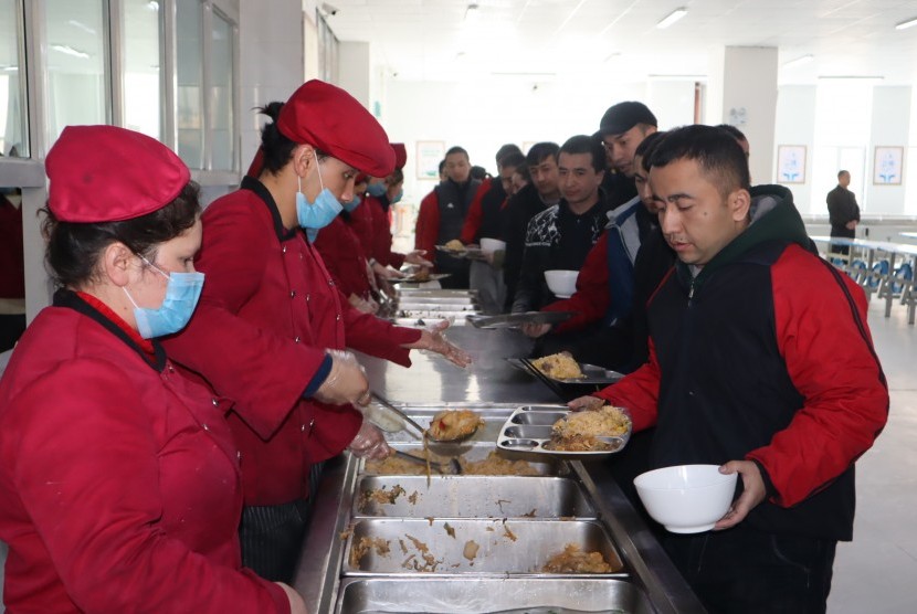Para peserta didik kamp pendidikan vokasi etnis Uighur di Kota Kashgar, Daerah Otonomi Xinjiang, Cina, antre makan siang di kantin saat jam istirahat, Jumat (3/1/2019). 