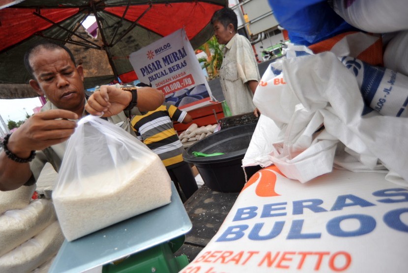 Petugas Bulog mengemas beras saat digelarnya pasar murah di Pasar Raya Padang, Sumatera Barat, Selasa (8/1/2019).