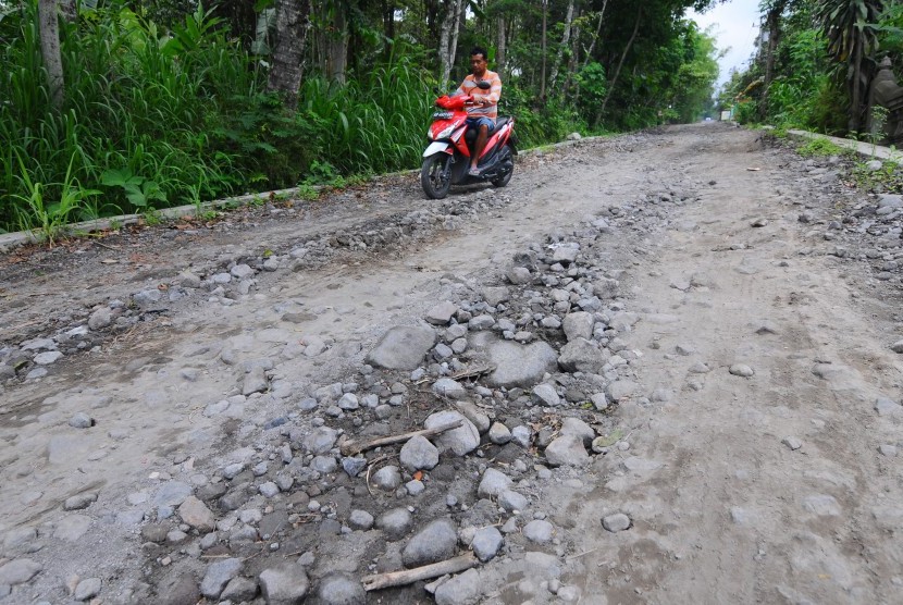 Warga mengendarai motor melintasi jalur evakuasi Merapi yang rusak di Tlogowatu, Kemalang, Klaten, Jawa Tengah, Kamis (10/1/2019). 