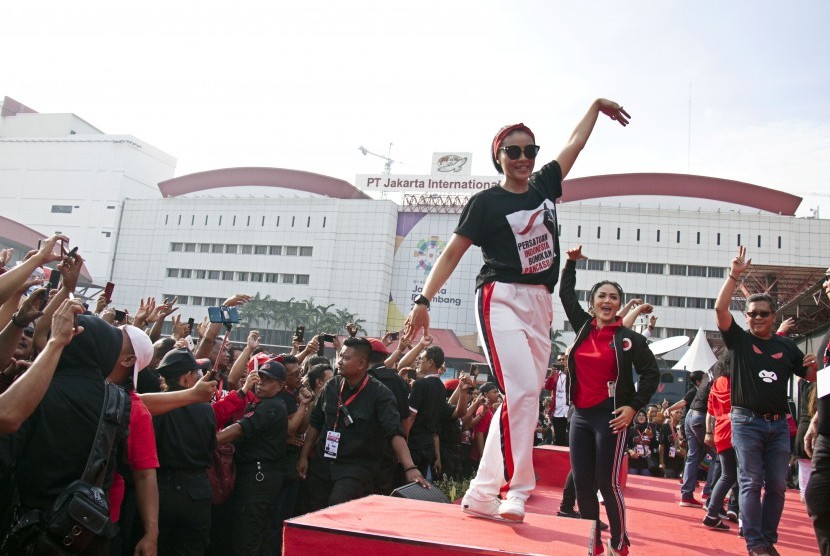 Sekjen PDI Perjuangan (PDIP) Hasto Kristiyanto (kanan), calon anggota legislatif Krisdayanti (kedua kanan) bersama kader dan simpatisan PDIP melakukan senam bersama saat peringatan HUT ke-46 PDIP di JIExpo Kemayoran, Jakarta, Jumat (11/1/2019).