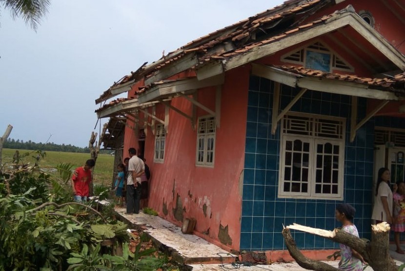 Warga Desa Muktijaya, Kecamatan Cilamaya Kulon, Kabupaten Karawang, memerbaiki rumah mereka yang rusak akibat tersapu angin ribut, Jumat (11/1).
