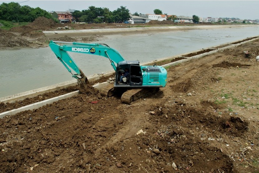 Pekerja mengoperasikan eskavator saat meratakan tanah di sisi tanggul sungai pada proyek normalisasi Sungai Banjir Kanal Timur (BKT) di Semarang, Jawa Tengah, Senin (14/1/2019).