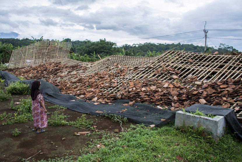 Warga melihat kandang ayam yang roboh akibat diterjang angin puting beliung di Kampung Cibarengkok, Nagrak, Kabupaten Sukabumi, Jawa Barat, Rabu (16/01/2019).