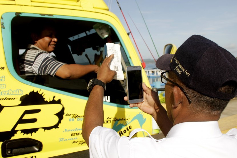 Petugas PT. Angkutan Sungai, Danau dan Penyeberangan (ASDP) Indonesia Ferry, menscan barcode tiket masuk milik seorang pengemudi truk. ASDP menyebut, transaksi pembayaran nontunai memudahkan pengguna jasa.