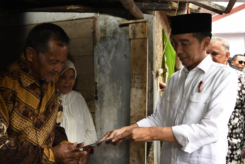 Presiden Joko Widodo (kanan) berbincang dengan penerima fasilitas pemasangan listrik gratis di Kampung Pasar Kolot, Garut, Jawa Barat, Jumat (18/1/2019).