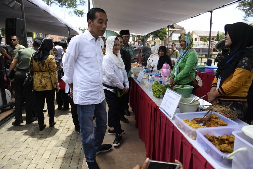 residen Joko Widodo (tengah) didampingi Ibu Negara Iriana Joko Widodo dan Gubernur Jawa Barat Ridwan Kamil meninjau Program Mekaar binaan PNM di Kampung Pasar Kolot, Garut, Jawa Barat, Jumat (18/1/2019). 