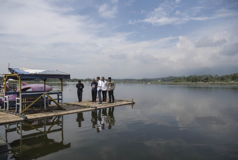 Presiden Joko Widodo (tengah) didampingi Menteri PUPR Basuki Hdimuljono (kedua kiri), Menteri Sosial Agus Gumiwang Kartasasmita dan Gubernur Jawa Barat Ridwan Kamil (kanan) meninjau Situ Bagendit di Garut, Jawa Barat, Sabtu (19/1/2019).