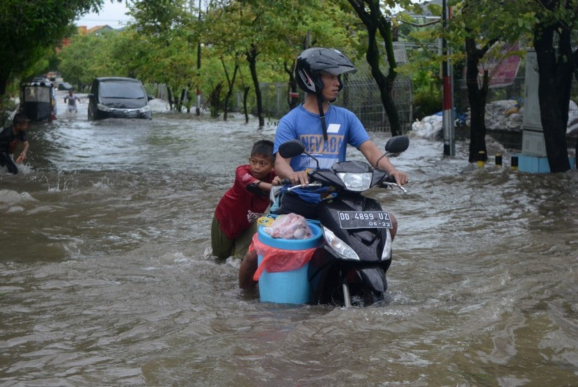 Pengendara melewati banjir di Jalan Pendidikan Makassar, Sulawesi Selatan, Selasa (22/01/2019).