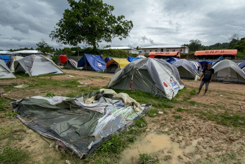 Warga berada di dekat tendanya yang rusak diterjang angin dan hujan di Kamp Pengungsi Kelurahan Gunung Bale, Donggala, Sulawesi Tengah, Selasa (22/1/2019).