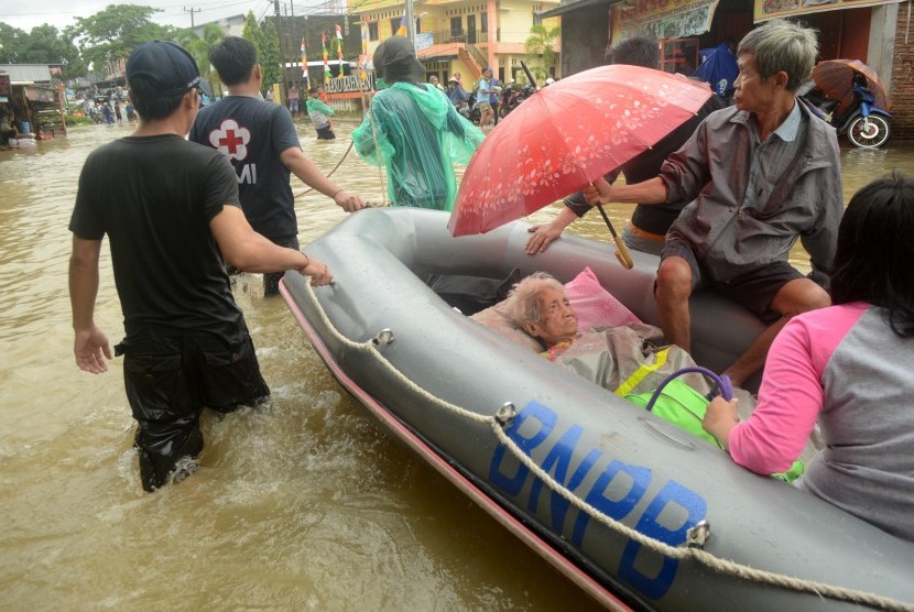 Tim relawan mengevakuasi warga korban banjir di Kelurahan Paccerakkang, Makassar, Sulawesi Selatan, Selasa (22/01/2019). 