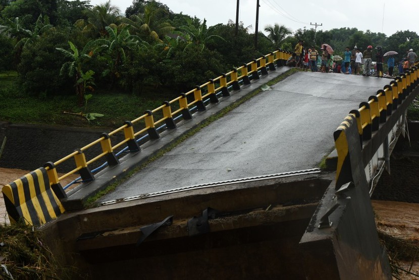 Warga menyaksikan Jembatan Manuju yang ambruk akibat diterjang air di Desa Moncongloe, Manuju, Kabupaten Gowa, Sulawesi Selatan, Rabu (23/1/2019).