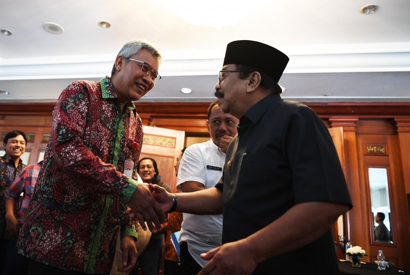 Gubernur Jawa Timur Soekarwo (kanan) berbincang bersama Kepala Bank Indonesia Jawa Timur Difi Ahmad Djohansyah (kiri) seusai pertemuan Tim Pengendalian Inflasi Daerah (TPID) di Surabaya, Jawa Timur, Rabu (23/1/2019).