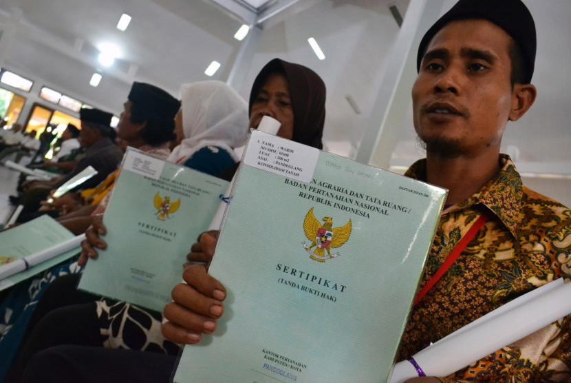 Warga menunjukan sertifikat tanah yang dibagikan pemerintah di Pendopo Bupati Pandeglang, di Pandeglang, Banten, Rabu (23/1/2019).