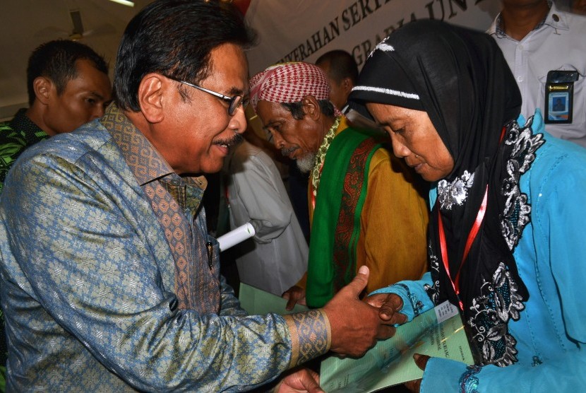 Menteri Agraria dan Tata Ruang/Kepala Badan Pertanahan Nasional Sofyan Djalil (kiri) secara simbolis menyerahkan sertifikat tanah kepada warga di Pendopo Bupati Pandeglang, di Pandeglang, Banten, Rabu (23/1/2019).