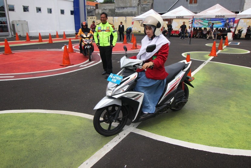 Pelajar mempraktekkan cara berkendara motor di area ujian praktek Surat Ijin Mengemudi (SIM) di Satuan Penyelenggara Administrasi SIM (Satpas) Colombo, Surabaya, Jawa Timur, Kamis (24/1/2019).