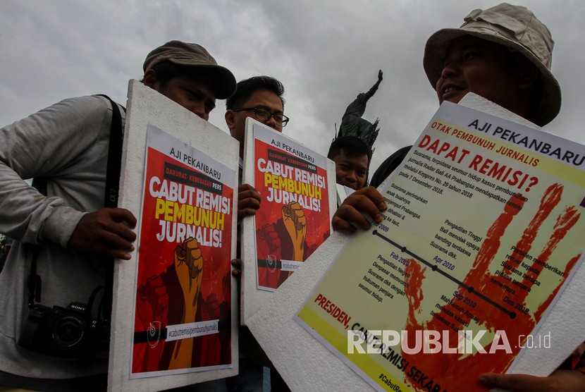 Jurnalis membentangkan spanduk dan poster untuk memberi dukungan dalam aksi damai 'Cabut Remisi Pembunuh Jurnalis' di Pekanbaru, Riau, Ahad (27/1/2019).