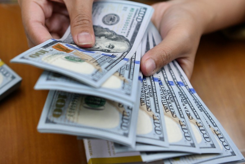 Karyawan menghitung mata uang dolar Amerika Serikat di gerai penukaran mata uang asing. ilustrasi