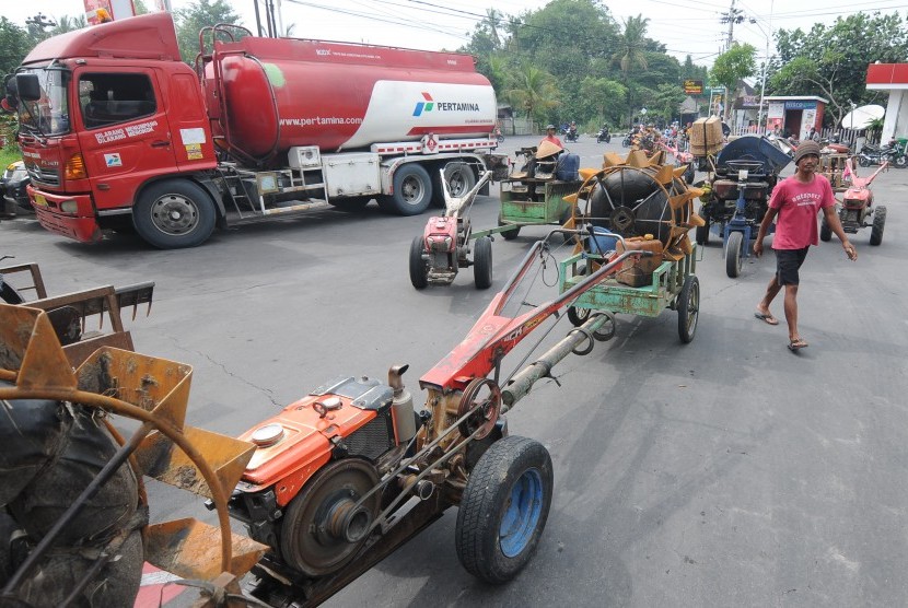 Sejumlah pemilik jasa penyedia alat pertanian membawa traktor dan mesin penggilingan padi atau tleser saat melakukan aksi protes dihentikannya layanan penjualan solar di SPBU Karangduren, Sawit, Boyolali, Jawa Tengah, Senin (28/1/2019). 