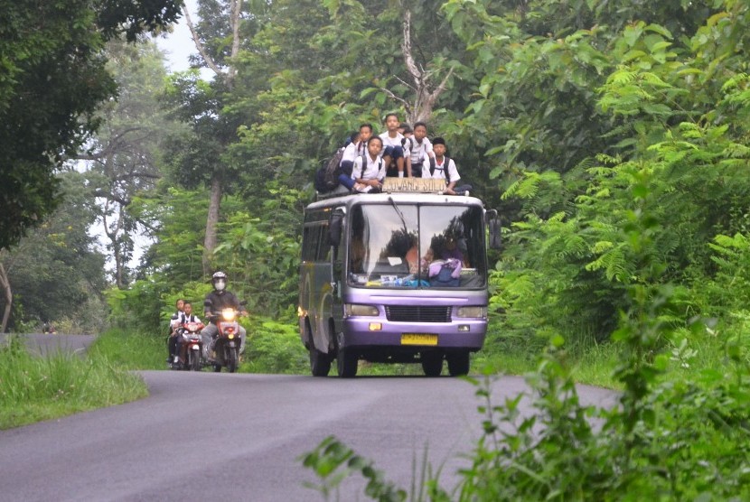 Sejumlah siswa duduk di atas bus yang melintas di jalan Solo-Purwodadi, Kedungombo, Sumberlawang, Sragen, Jawa Tengah, Senin(28/1/2019).