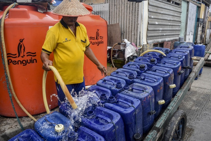 Serang pekerja mengisi air bersih ke dalam jerigen untuk dijual di Muara Angke, Jakarta, Senin (28/1/2019).