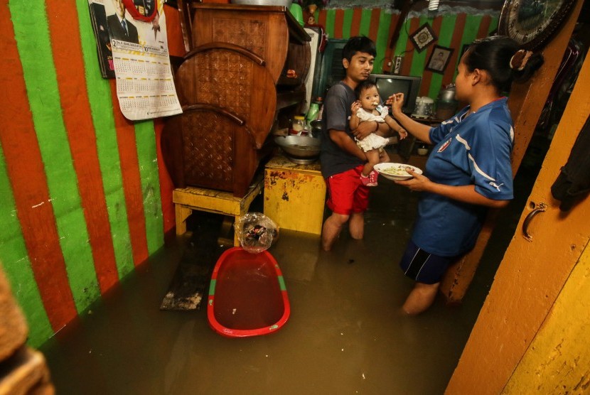 Warga beraktivitas di dalam rumahnya saat banjir mengggenangi kawasan Rawa Buaya di Jakarta Barat, Rabu (30/1). Rawa Buaya adalah salah satu contoh daerah di DKI Jakarta yang memiliki banyak cekungan.