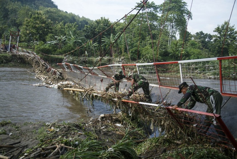 Anggota TNI membersihkan sampah yang tersangkut di jembatan Kalijogo, Dusun Karang Wetan, Tegaltirto, Berbah, Sleman, DI Yogyakarta, Kamis (31/1/2019).