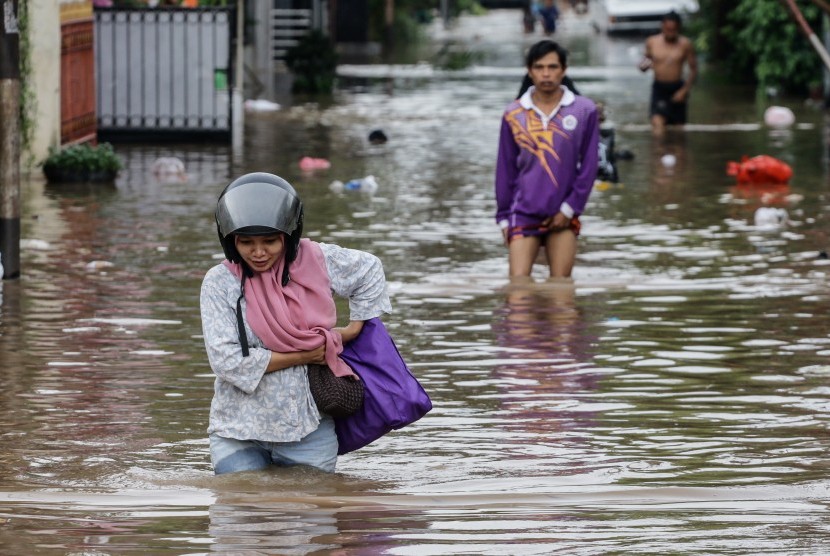 Warga melintasi banjir. (Ilustrasi)