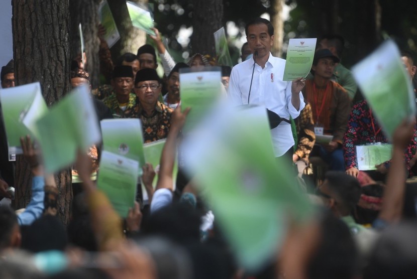 Presiden Joko Widodo menunjukkan Surat Keputusan tentang Pengelolaan Hutan Sosial saat berpidato di Wana Wisata Pokland Haurwangi, Cianjur, Jumat (8/2/2019).