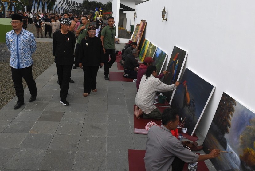 Presiden Joko Widodo (tengah) berjalan didampingi Gubernur Jawa Barat Ridwan Kamil (kiri) dan Plt Bupati Cianjur Herman Suherman (kanan) saat meninjau Alun-alun kota Cianjur, Jawa barat, Jumat (8/2/2019).