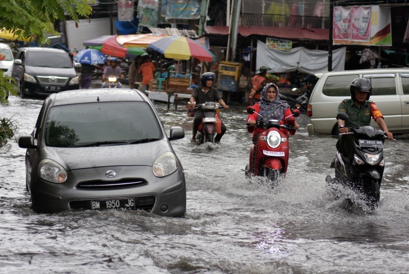 Sejumlah pengendara kendaraan melewati banjir yang menggenangi Jalan M. Yatim Kota Pekanbaru, Riau (ilustrasi).
